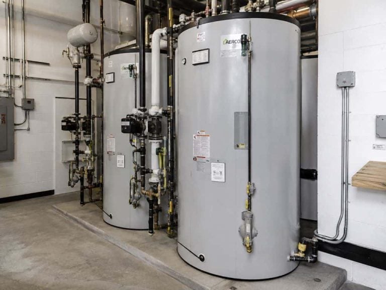Two commercial water heaters with connected piping installed in a mechanical room in Boerne, TX.