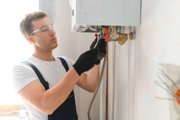 Local plumber fixing a water heater and repairing leaks in Blanco